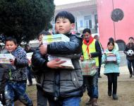 2016年1月8日下午,在駐馬店市汝南縣三門閘街道大新莊小學(xué)校院內(nèi)，駐馬店市陽光助學(xué)協(xié)會負(fù)責(zé)人及志愿者、大新莊學(xué)校師生、學(xué)生家長歡聚一堂，舉行了“陽光助學(xué)愛心圖書室”捐贈儀式。圖為學(xué)生和志愿者一起搬運新書