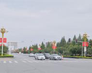 駐馬店市開(kāi)源大道，道路兩旁清一色的紅旗在迎風(fēng)飄揚(yáng)。所有紅旗都是在燈桿的一側(cè)逆時(shí)針旋轉(zhuǎn)90°豎著懸掛，鮮艷的國(guó)旗整齊地朝向一側(cè)，非常壯觀。