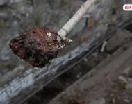 在遷安市中化煤化工有限責任公司的圍墻外是污水排放溝，溝里的泥成為紅褐色。