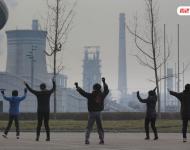 圖為耗資13億建成的邯鄲武安市體育館外，本地的不少中年婦女，每天會在固定時間來到這里：她們背對體育館，面向文安鋼鐵廠，跳起了廣場舞。邯鄲武安市區(qū)有十幾個鋼鐵廠、電廠、焦化廠包圍，不管刮什么風，城區(qū)污染都很嚴重。視覺中國